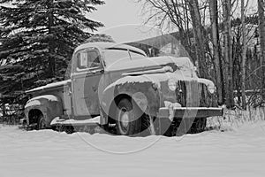 Old truck covered in snow