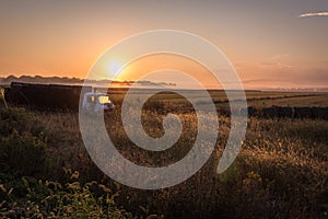 Old truck on a farm field at sunrise