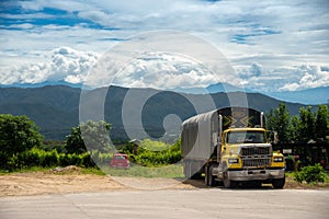 Old truck parked on a road with mountain ranges in the background. Colombia.