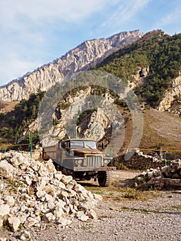 Old truck stands against the background of mountains