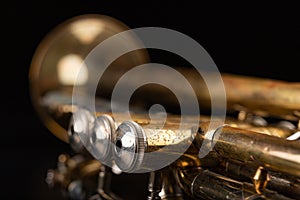 Old trumpet on a dark wooden table. Wind instrument in the old style