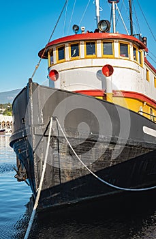 Old tugboat in a sunny summer day. Tug boats are working in a harbor. Offshore supply boat in a calm weather day