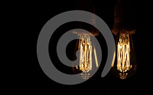 Old tungsten light bulb with their golden glow suspended with thick rope hangers