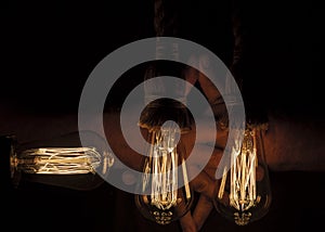 Old tungsten light bulb with their golden glow suspended with thick rope hangers