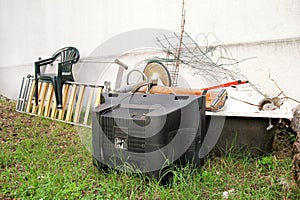 Old TV set and the rest of bulky trash. Old TV thrown away next to a wall with a pile of mixed garbage.