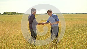 Old two farmers explore are studying handshake . man Wheat Field summer in the field wheat bread. slow motion video