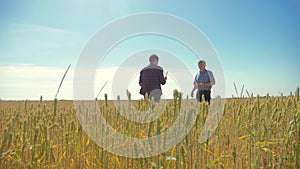 Old two farmers summer man Wheat Field running in the field wheat bread. slow motion video. farmer ecology concept