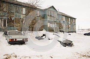 Old two-storied blue house in winter with snow outdoor. Poverty and misery, North