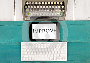 old typewriter keyboard and modern computer keyboard and tablet pc with word & x22;IMPROVE& x22;