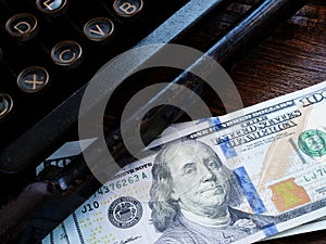 Old typewriter and money as a symbol of monetization and royalties for an article.