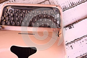 Old typewriter painted in pink, which reminds us of what technology was like at the end of the 19th century and almost the entire