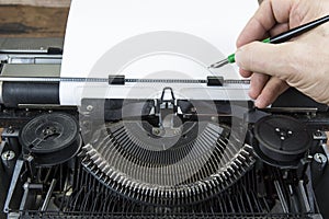 Old typewriter from seventies with paper and copy space. With writing hand