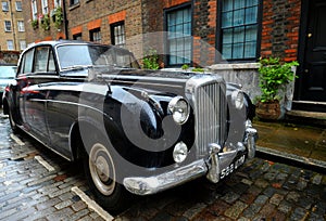 Old typical brick house in Shoreditch London with Bentley vintage car