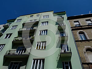 Old typical mid-rise condominium building in Budapest in low angle view with small balconies