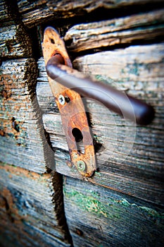 The old ugly rusty latch on wooden door