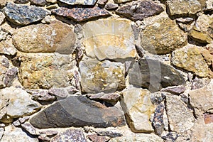 Old uneven, rough, irregular granite stone wall. Natural textured background.