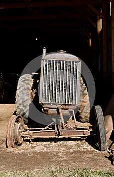 Old unidentifiable tractor missing a front tire