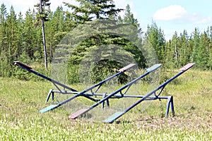 Old unmaintained teeter totters in an abandoned playground