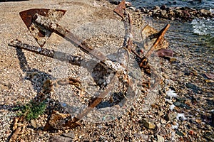 Old unused rusty anchor on the sea shore