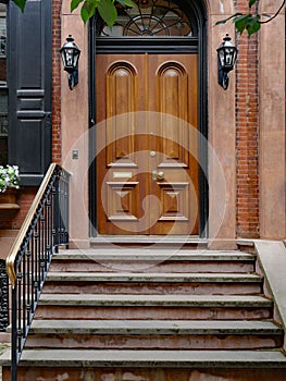 old urban brownstone type townhouse with polished double wooden door