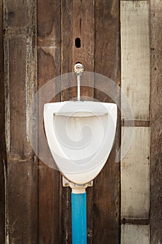 Old urinal on wooden wall