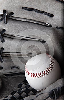 Old used baseball glove and ball isolated closeup