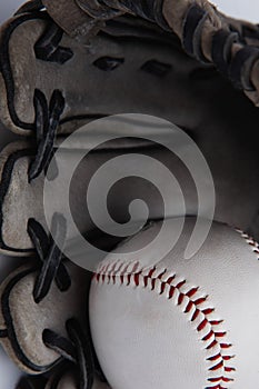 Old used baseball glove and ball isolated closeup