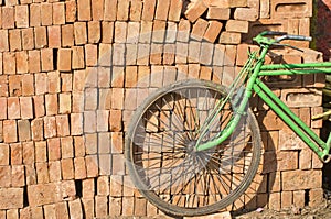 Old used bicycle near red bricks stack, India
