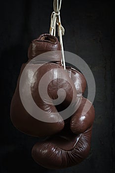 Old used boxing Gloves, hanging before a dirty Wall