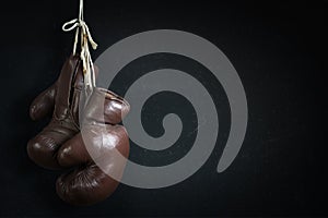 Old used boxing Gloves, hanging before a dirty Wall