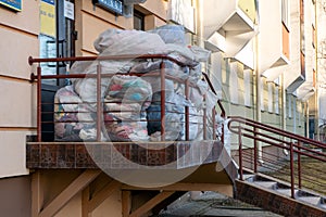 Old used clothes in plastic bags. New arrival of the goods in the second-hand store. Humanitarian aid for children affected by the