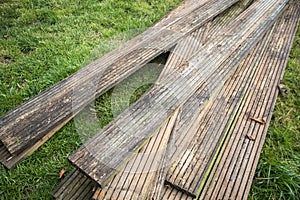 Old used decking planks on grass photo