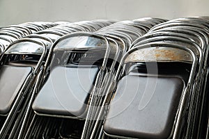 Old and Used Fold Rusty Metal Chairs Lay on the Wall