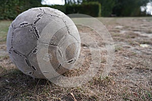 Old used football or soccer ball the grass.