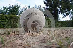 Old used football or soccer ball the grass.