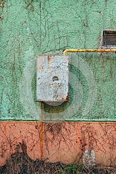 Old used gas meter on house external wall photo