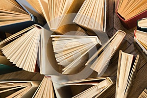 Old and used hardback books, text books seen from above on wooden floor. Books and reading are essential for self improvement, ga