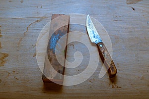 Old used knife and whetstone. Old knife with a wooden handle.