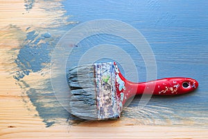 Old used paint brush on partial paint wood background. Horizontal position