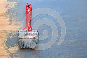 Old used paint brush on partial paint wood background. Vertical