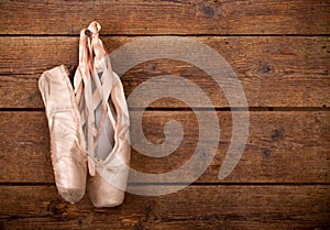 Old used pink ballet shoes hanging