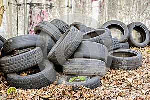 Old used rubbish tires lies near the wall