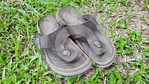 Old used sandals. Pair of old footwear on grass