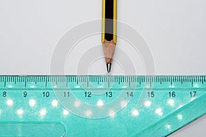 Old used triangle ruler and a pencil. Ruler and pencil.