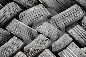 Old used weared car and truck wheels tyres pile stacked in rows stored for recycling. Heap of many rubber tires wall