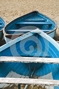 Old used wooden row boat on a sandy beach sand