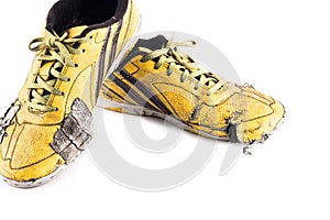 Old used  yellow worn out futsal sports shoes  on white background soccer sportware object isolated