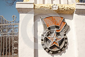 Old USSR wall relief, runner in a star. Sports emblem with a flag