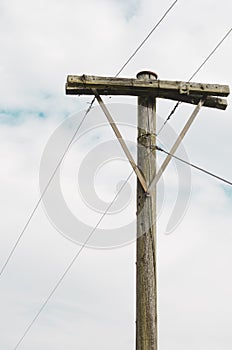 Old utility pole with a cloudy sky.