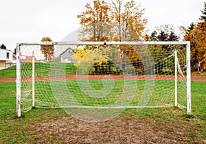 Old vacant football soccer goal gate in rural grass field.